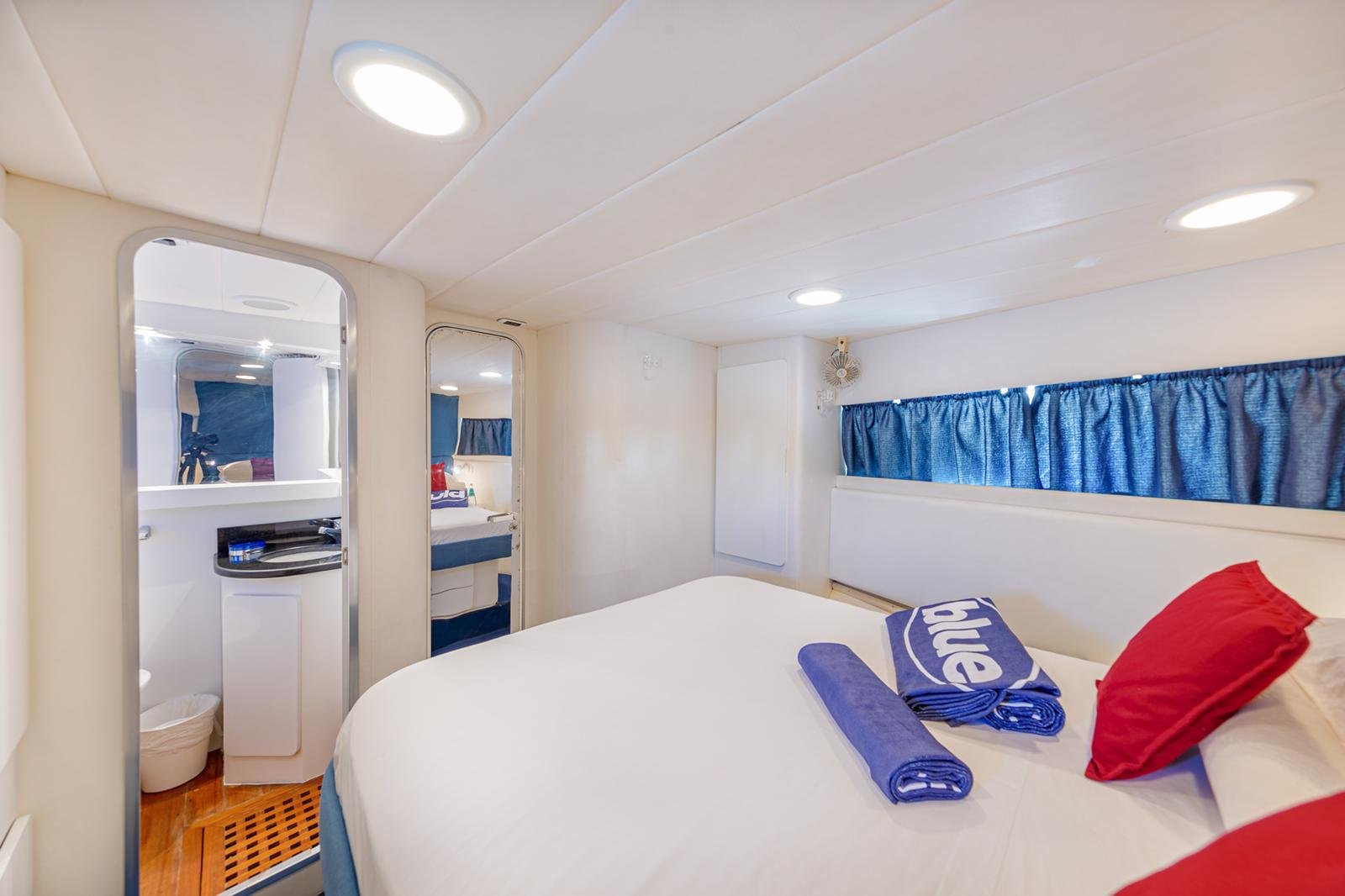 Cabina matrimoniale con biancheria blu a bordo